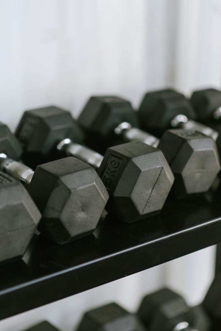 Close-up of hex dumbbells neatly arranged on a rack in a gym, perfect for fitness themes.